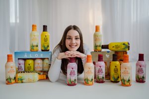 Jeune femme avec les 4 versions de la boisson aloe vera Forever